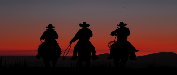 Three silhouetted cowboys on horses riding into sunset